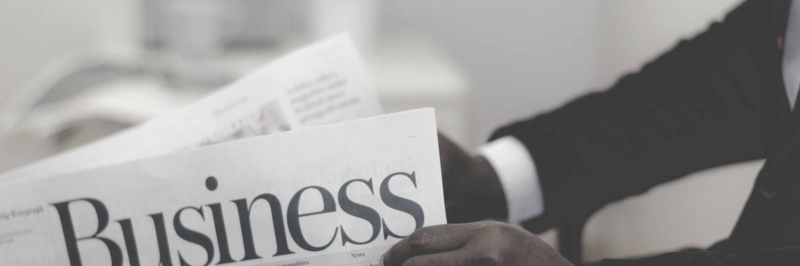 Person in a suit reading a business newspaper