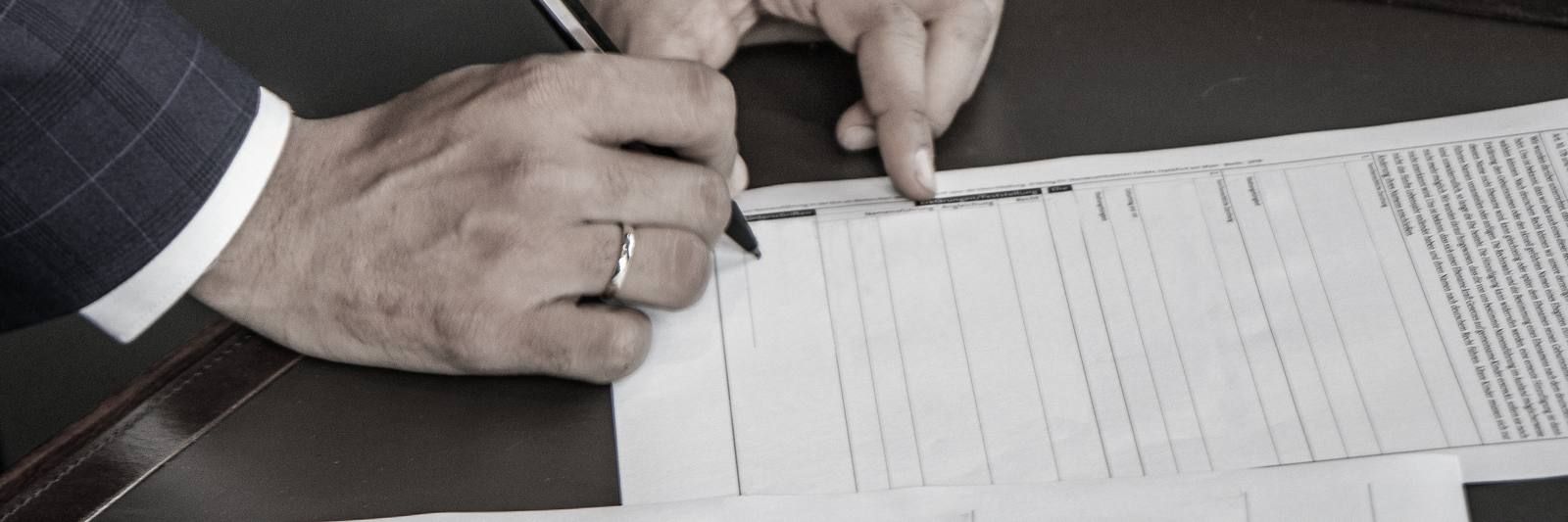 Hand filling out a printed form