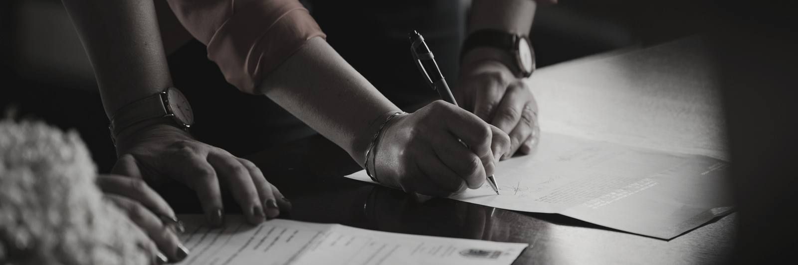 Hand annotating a blank sheet on a desk